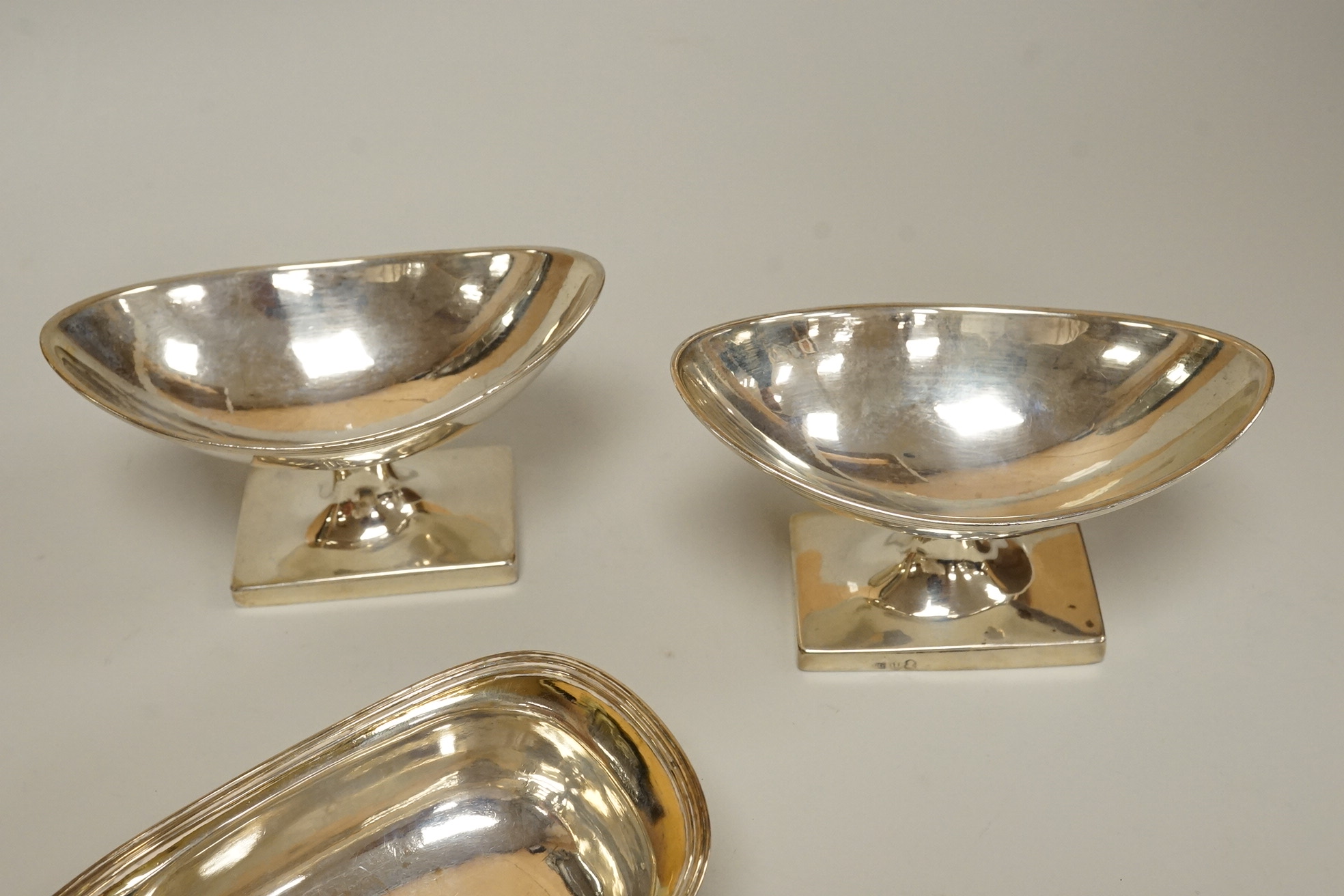 A George III silver pap boat, maker ?? and EB, London 1812, length 12.1 cm, together with a pair of Georgian Scottish silver boat shaped pedestal salts, maker RG, gross weight 7oz.
